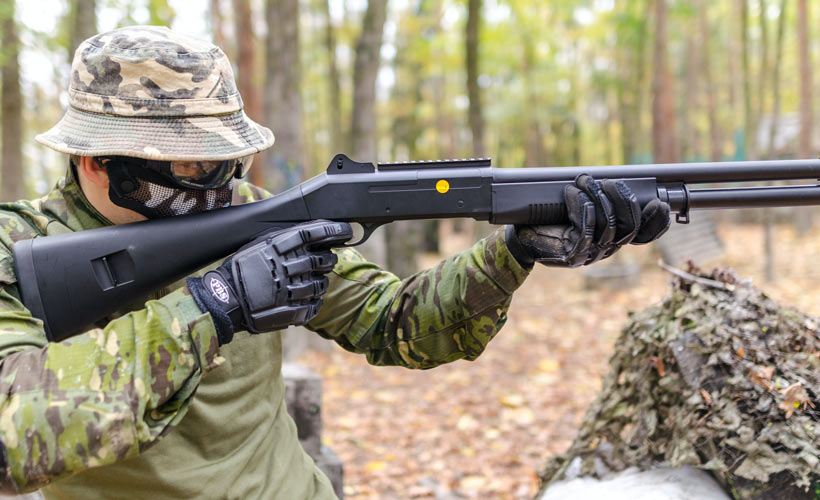 Airsoft replica shotgun being used in an outdoor environment